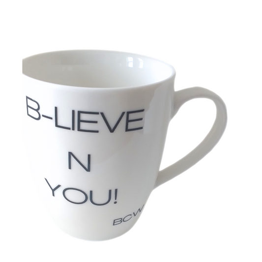 White mug with 'B-LIEVE N YOU!' text on a white background